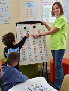 Children working at the board with a teacher