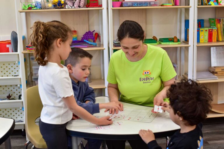 A teacher working with children at a table