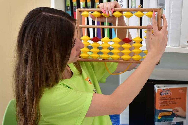 A teacher demonstrating mental math on an abacus